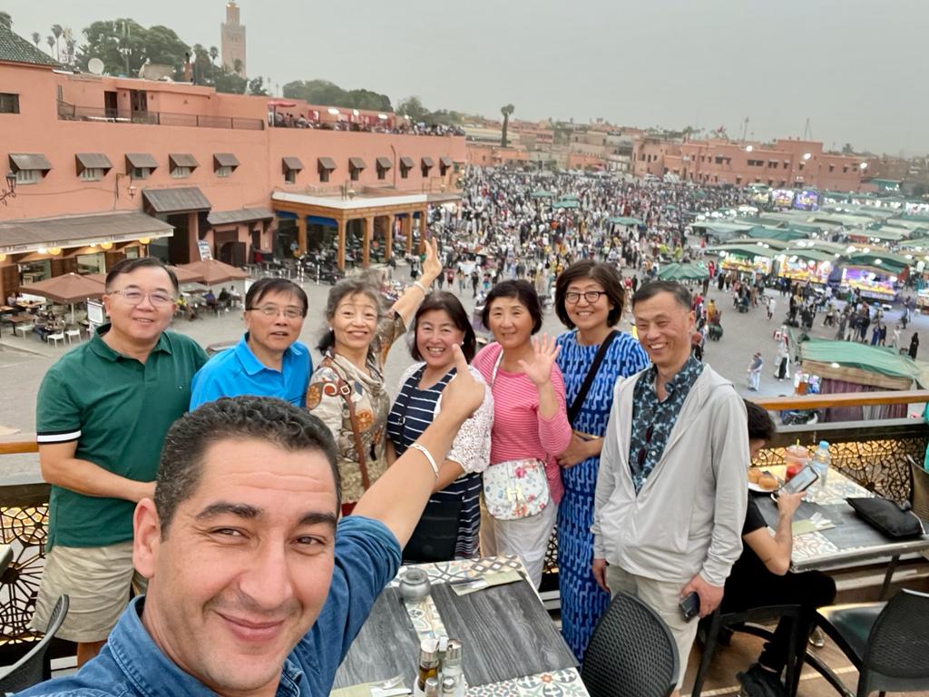 Guide and travelers sharing a moment at Jemaa el-Fna, Marrakech